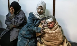 Une femme syrienne et des enfants blessés patientent dans un hôpital après des frappes sur le quartier de Barzé, en périphérie de Damas, le 20 février 2017