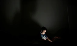 Un enfant joue sur un smartphone dans sa chambre à San Salvador en octobre 2018