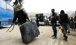 Des civils syriens et combattants rebelles arrivent dans le village de Qalaat al-Madiq, au nord de Hama, après avoir été évacués de Harasta située dans la Ghouta orientale, le 24 mars 2018
