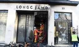Les pompiers interviennent sur un feu à la boutique Longchamp, pendant la manifestation des "gilets jaunes", sur les Champs-Elysées à Paris, le 16 mars 2019