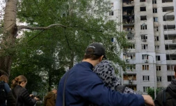 Des habitants observent un immeuble résidentiel endommagé après une frappe de drone russe à Kiev, le 25 septembre 2026