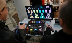 Des personnes jouent à un jeu vidéo fabriqué à partir de composants électroniques recyclés lors de la 3e Rencontre fédérale Cyberciruja à Buenos Aires, le 16 août 2025 en Argentine