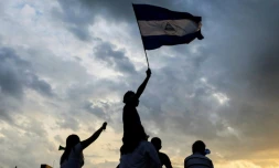 Des manifestants brandissent un drapeau du Nicaragua lors d'une manifestation contre le gouvernement, le 15 mai 2018 à Managua
