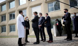 Le président français Emmanuel Macron (c) parle à des soignants lors d'une visite au service pédopsychiatrique du CHU de Reims, le 14 avril 2021