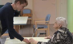 Un adolescent tient la main d'une patiente atteinte de la maladie d'Alzheimer le 18 octobre 2016 à Saint-Quirin dans l'est