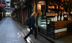 Une femme entre dans un café dans une rue normalement animée du quartier d'affaires de Melbourne, le 6 août 2020 en Australie