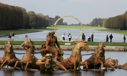Des visiteurs marchent dans les jardins de Versailles, passant devant une sculpture de l'artiste suisse Ugo Rondinone, le 19 octobre 2017