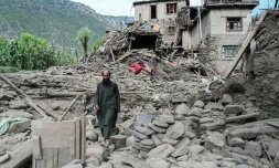 Un homme afghan passe devant une maison endommagée à la suite de tremblements de terre dans le village de Mazar Dara, situé dans le district de Nurgal, dans la province de Kunar, à l'est de l'Afghanistan, le 1er septembre 2025 après un séisme de magnitude 6,0