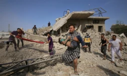 Un homme transporte un enfant dans la localitĂ© de Maaret al-Noomane dans la province d'Idleb en Syrie, oĂč des secouristes cherchent des survivants dans les dĂ©combres aprĂšs une frappe aĂ©rienne du rĂ©gime syrien et son alliĂ© russe selon une ONG, le 30 mai 2019