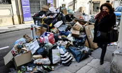 Une passante près d'un empilement d'ordures non ramassées en raison d'une grève des éboueurs, à Marseille le 3 février 2020