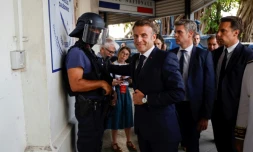 Le président français Emmanuel Macron (C) arrive au commissariat central de Nouméa, en Nouvelle-Calédonie, le 23 mai 2024