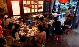 Des habitants dînent à la terrasse d'un restaurant, le 6 juin 2022 à Pékin