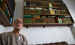 Mustafa Khaled Alwan devant sa bibliothèque, à son domicile à Homs, en Syrie, le 19 septembre 2026