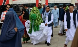 Un couple de jeunes mariés afghans sort d'une cérémonie de mariage collectif à Kaboul, le 13 juin 2022
