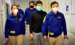 Nicolas Zepeda (en noir) est excorté par la police chilienne à son arrivée à l'aéroport de Santiago, le 23 juillet 2020.