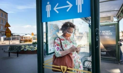 Une passante à Stockholm, le 26 juin 2020 devant une affiche recommandant la distanciation sociale