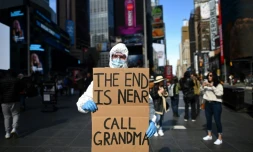 Un homme brandissant une pancarte "La fin est proche, appelle Mamie", le 14 mars 2020 à New York