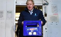 Le Premier ministre Boris Johnson porte un pack de bouteilles de lait  à Guiseley, dans le cadre de sa campagne électorale le 11 décembre 2019