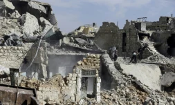 Famille syrienne parmi les décombres d'une maison du quartier de Karm al-Jabal à Alep, le 9 mars 2017