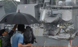 Un caméraman filme dans le port de Tokyo le 18 mai 2017 un destroyer américain entré en collision avec un cargo