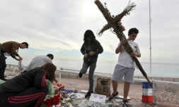 Des bénévoles ramassent les messages et objets laissés sur la Promenade des Anglais, le 16 octobre 2016, trois mois après l'attentat de Nice