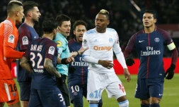 L'attaquant marseillais Clinton Mua Njie (2ndR) discutant avec le défenseur du Paris SG, Dani Alves, à la droite de l'arbitre, au cours du match opposant le PSG à Marseille, le 25 février 2018 au Parc des Princes, à Paris