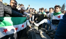 Des étudiants traînent la statue de l'ancien président Hafez al-Assad près du campus de l'université de Damas, le 15 décembre 2024 en Syrie