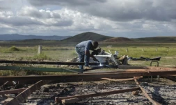 Un homme découpe la structure d'un abri utilisé par des réfugiés vénézuéliens et détruit par des Brésiliens, le 20 août 2018 à Pacaraima, au Brésil