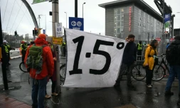 Des manifestants autour d'une banderole appelant à limiter le réchauffement de la planète à +1,5°, en marge de la COP26, à Glagow, en Ecosse