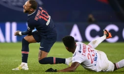 L'attaquant brésilien du Paris Saint-Germain, Neymar, taclé par son compatriote de Lyon, le milieu de terrain Thiago Mendes, lors de leur match de L1, le 13 décembre 2020 au Parc des Princes