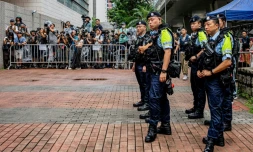 Des policiers près de l'espace réservé aux médias devant les tribunaux de première instance de West Kowloon, avant le verdict du procès pour atteinte à la sécurité nationale de deux militants prodémocratie de la mémoire de Tiananmen, à Hong Kong, le 21 août 2026