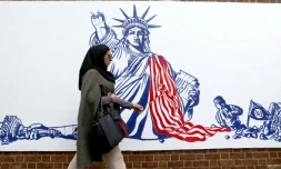 Une Iranienne passe devant une fresque murale sur l'enceinte de l'ancienne ambassade américaine à Téhéran, le 2 novembre 2019