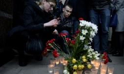 Des personnes déposent des fleurs et des bougies en mémoire aux victimes de l'attentat du métro, devant la station Sennaya, le 3 avril 2017 à Saint-Pétersbourg