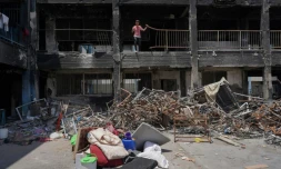 Des déplacés palestiniens déblaient les décombres d'un bùtiment endommagé à Khan YounÚs, dans le sud de la bande de Gaza, le 9 mai 2024