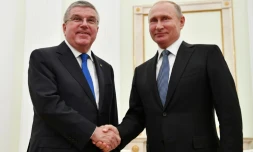 Le président russe Vladimir Poutine (d.) serre la main du président du Comité international olympique (CIO) Thomas Bach lors de leur rencontre au Kremlin à Moscou, le 15 juillet 2018