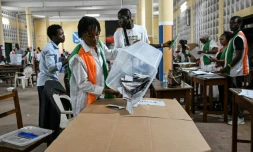 Une représentante de la commission électorale vide une urne pour le dépouillement des votes de la présidentielle ivoirienne, le 25 octobre 2025 à Abidjan