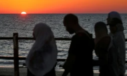 Le soleil se couche sur la mer Méditerranée alors que des Palestiniens déplacés évacuent la ville de Gaza vers le sud de la bande de Gaza face aux bombardements israéliens, le 13 septembre 2025 dans la bande de Gaza