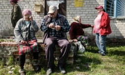 Des personnes ùgées attendent de recevoir leur pension à cÎté d'un camion postal qui est parvenu à se rapprocher de la ligne de front à Mayaky, est de l'Ukraine, le 6 mai 2022
