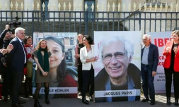 Cécile Kohler (3e G) et Jacques Paris (2e D) devant leurs portraits décrochés des grilles de l'Assemblée nationale, à Paris le 14 avril 2026