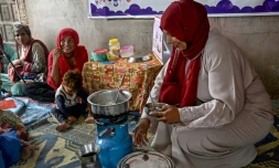 Une travailleuse sociale (d) montre à des mères comment préparer des repas nutritifs pour leurs enfants lors d'un programme de nutrition de l'Unicef au village de Fateh Muhammad Soomro, dans la province du Sindh, le 29 juillet 2025 au Pakistan