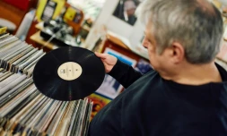 Un client examine un vinyle de la boutique Flashback Records, le 18 avril 2024 Ă Londres