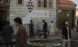 Des Afghans sur les lieux d'un attentat suicide contre un centre d'enregistrement électoral, le 22 avril 2018 à Kaboul