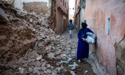 Une femme regarde les décombres d'un immeuble dans la vieille ville de Marrakech, endommagée par le tremblement de terre, le 9 septembre 2023