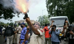 Un policier tire des grenades lacrymogĂšnes pour disperser des militants du "Parti du peuple des cafards" (CJP) lors d'une manifestation rĂ©clamant la dĂ©mission du ministre de l'Ăducation, Dharmendra Pradhan, en raison de fraudes prĂ©sumĂ©es aux examens universitaires, le 20 juillet 2026 Ă New Delhi, en Inde