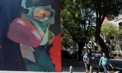 Passants prĂšs d'une fresque Ă Mexico, le 9 juin 2020