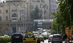 Des véhicules circulent dans une rue de Damas le 27 février 2016