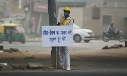 Un volontaire de la défense civile affiche un avertissement aux conducteurs aprÚs l'imposition de la circulation alternée en plein pic de pollution à New Delhi, le 4 novembre 2019