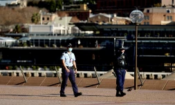 Des policiers patrouillent dans le quartier de l'opéra de Sydney, où le confinement a été prolongé pour au moins deux semaines