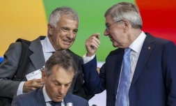 Le candidat espagnol à la présidence du Comité international olympique (CIO) Juan Antonio Samaranch Jr (g.) s'entretient avec le président sortant, l'Allemand Thomas Bach (d.), à côté du directeur général, le Belge Christophe De Kepper (c.), lors de la 144e session du CIO à Costa Navarino (Grèce), le 19 mars 2025