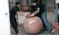 Inaki Goicoechea (g) et un artisan potier manipulent une jarre en terre cuite dans lequel ils font du vin à la manière des viticulteurs géorgiens, dans son atelier à Ossès ( sud-ouest de la France), le 12 octobre 2017
